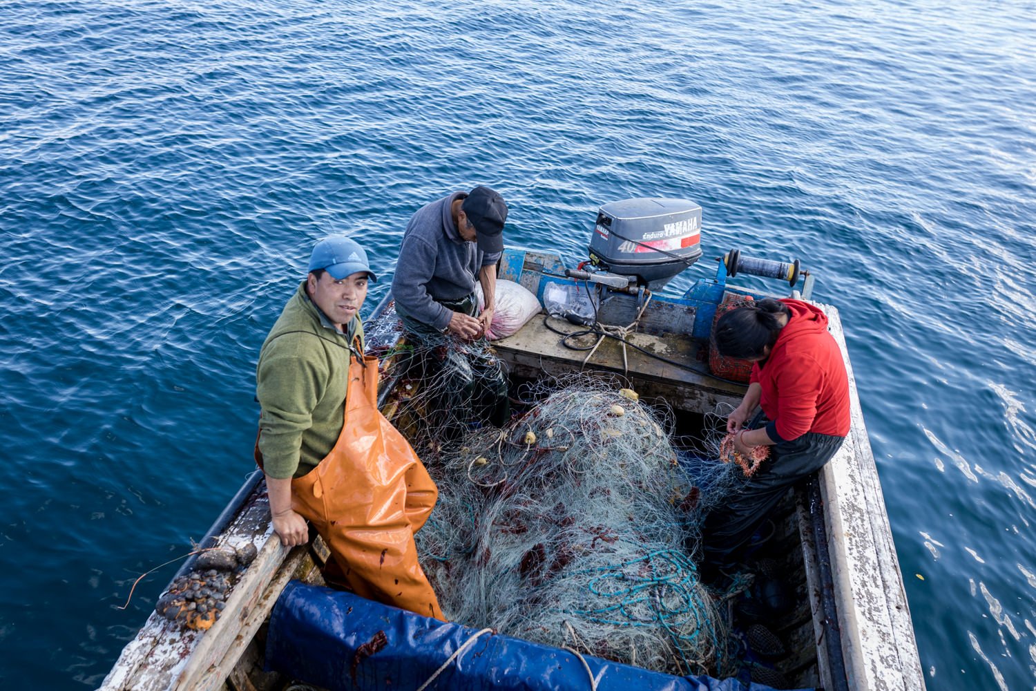 Pescadores con redes en un bote, vistos desde lo alto