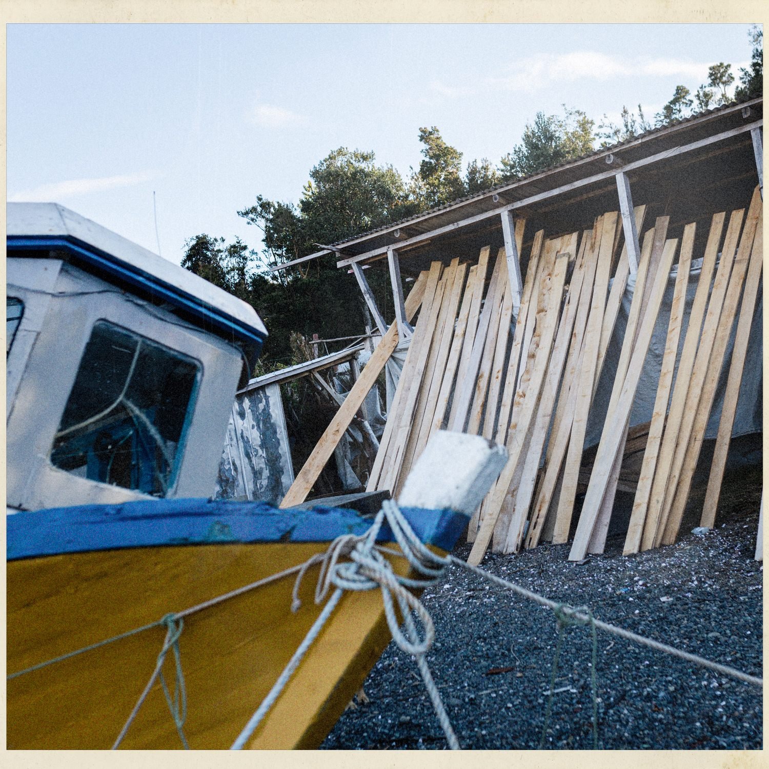Botes y maderas apoyados en la orilla de Apiao