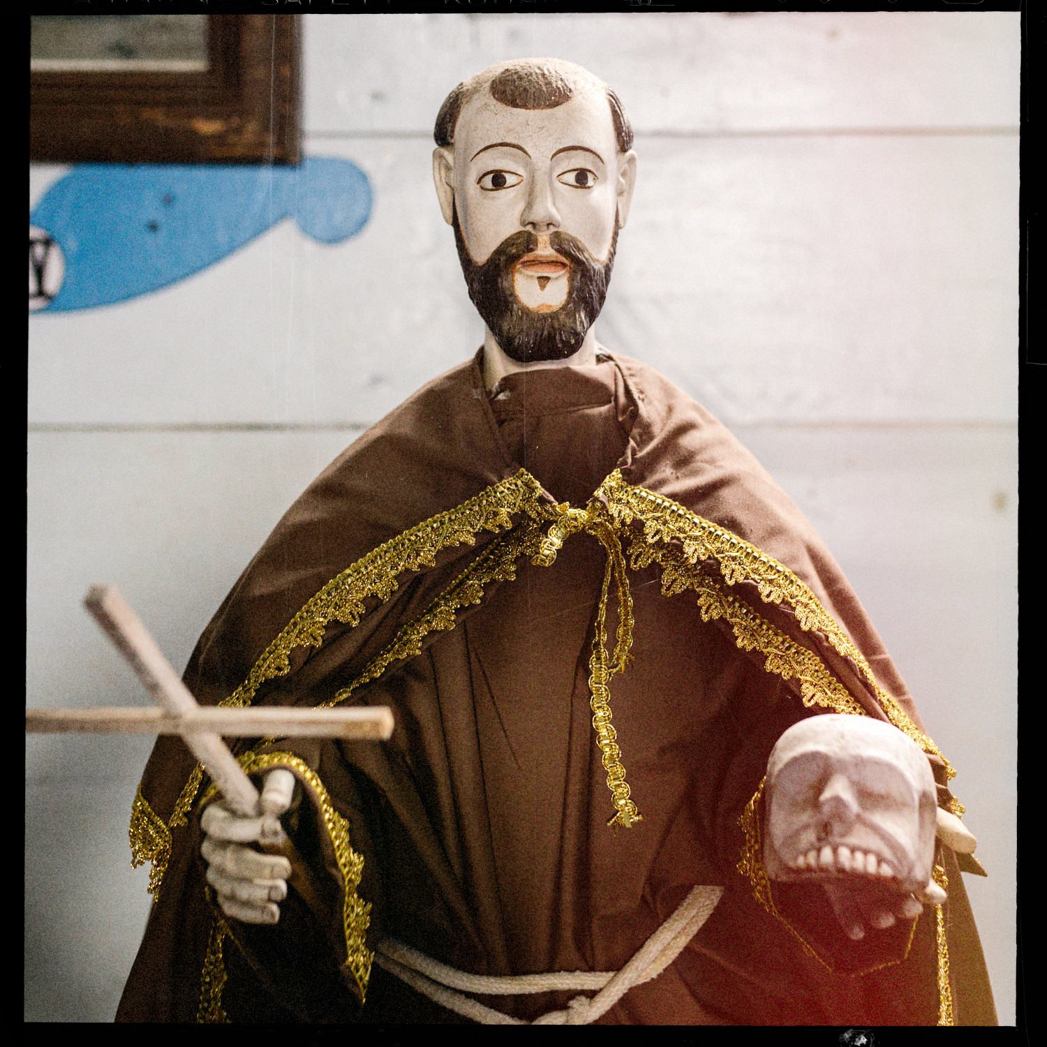 Imagen religiosa de un santo con hábito, cruz y calavera, en la iglesia de Apiao