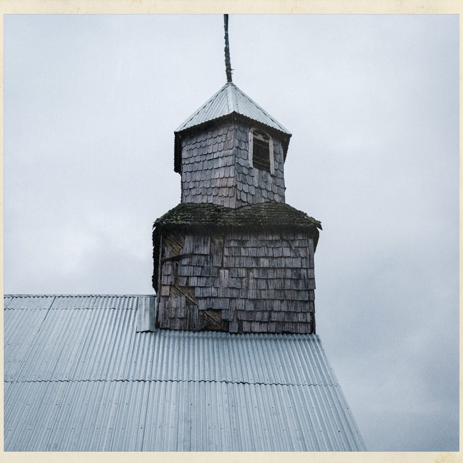 Torre de tejuelas de la iglesia de Apiao sobre el techo de zinc
