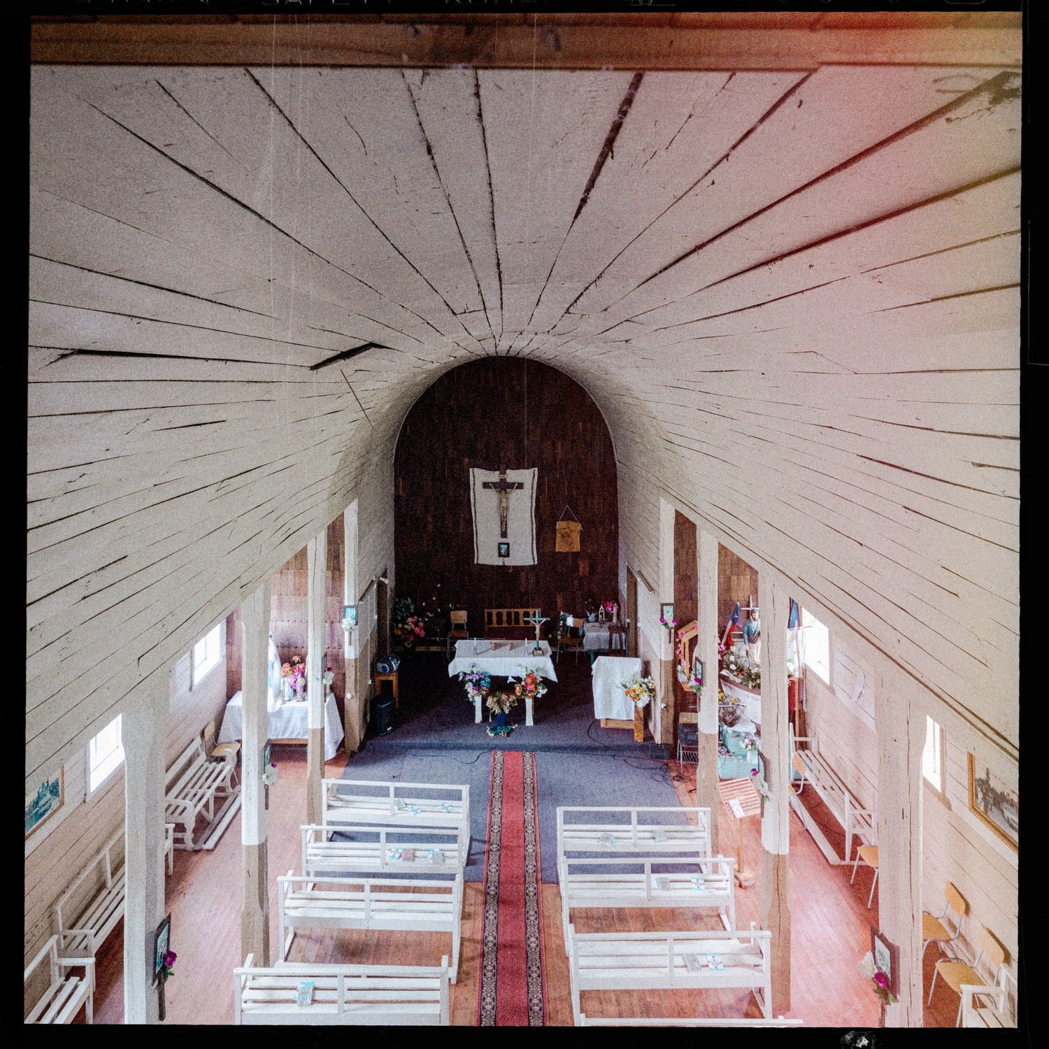 Nave y bóveda de madera de la iglesia de Caulín, con bancas blancas
