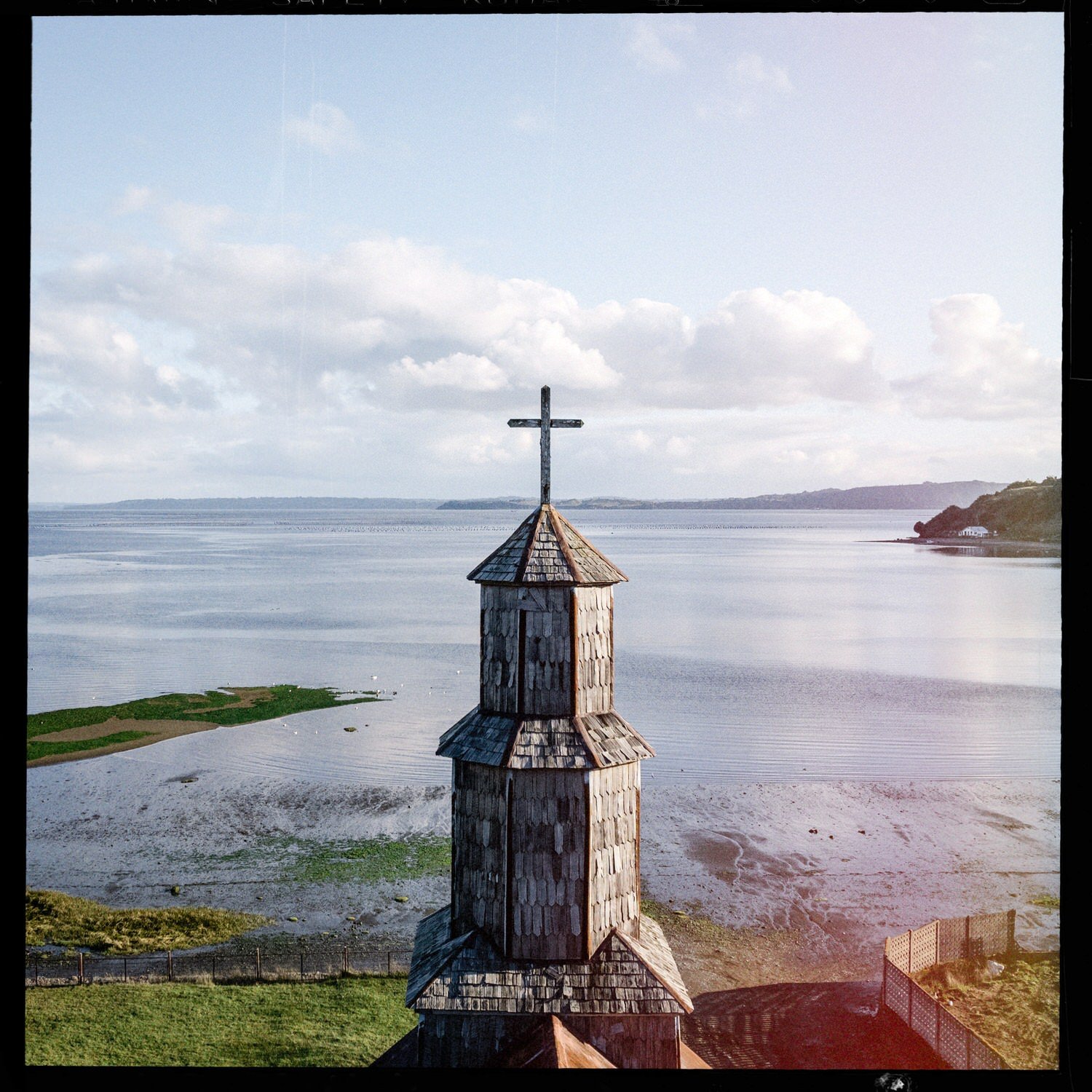 Torre de la iglesia de Chullec vista desde lo alto, con el mar al fondo