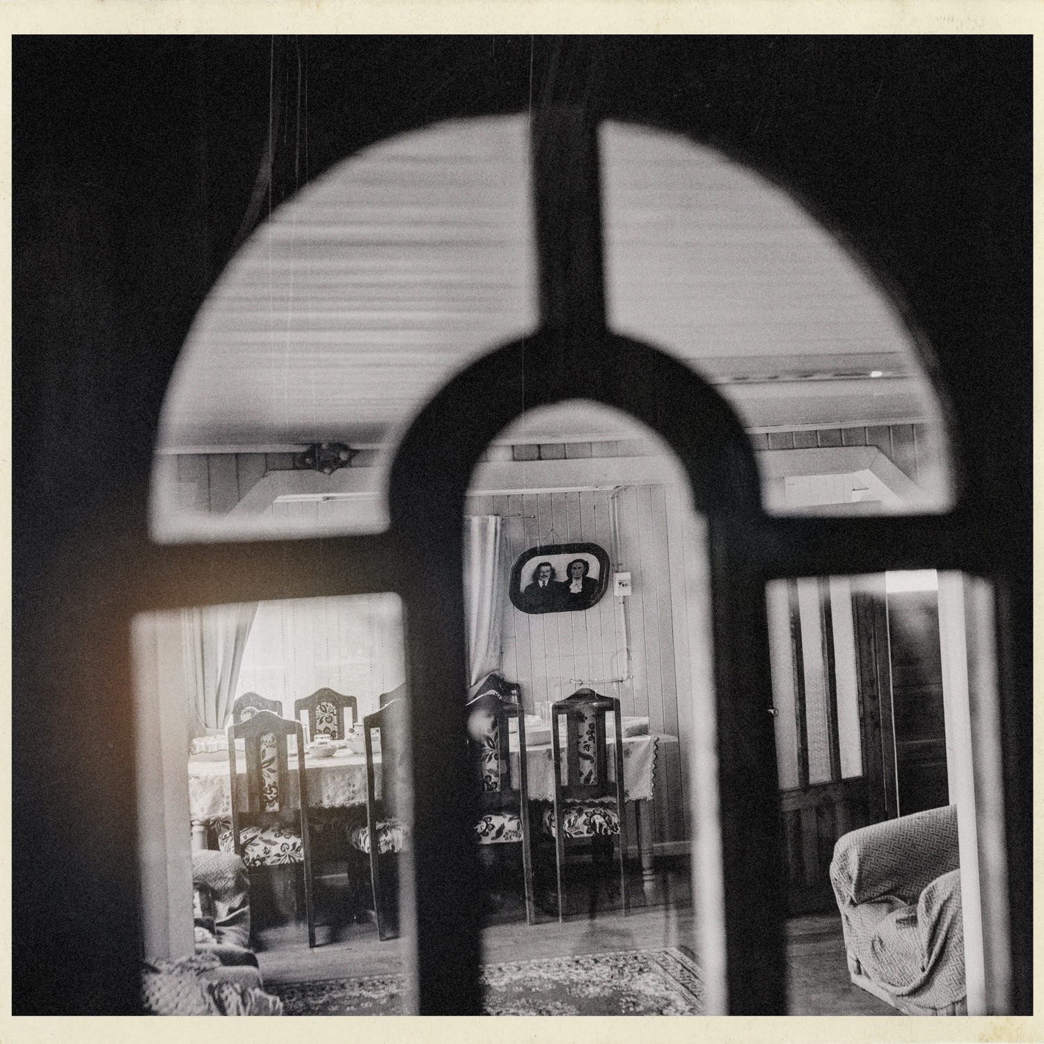 Interior de una casa visto a través de un vidrio, en blanco y negro