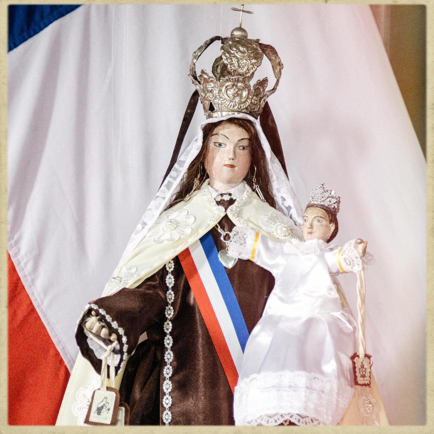 Imagen de la Virgen con el Niño, corona y banda tricolor, en la iglesia de Compu