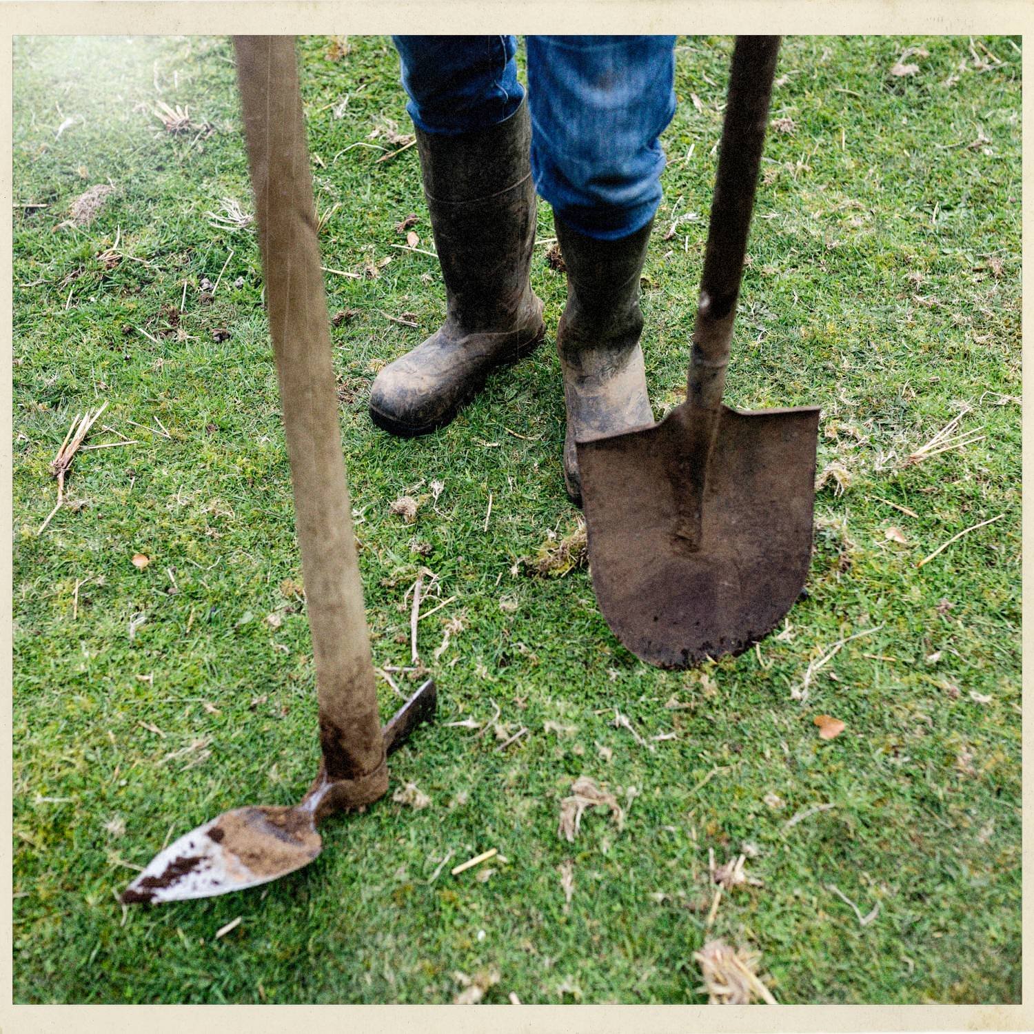 Botas de trabajo y una pala sobre el pasto