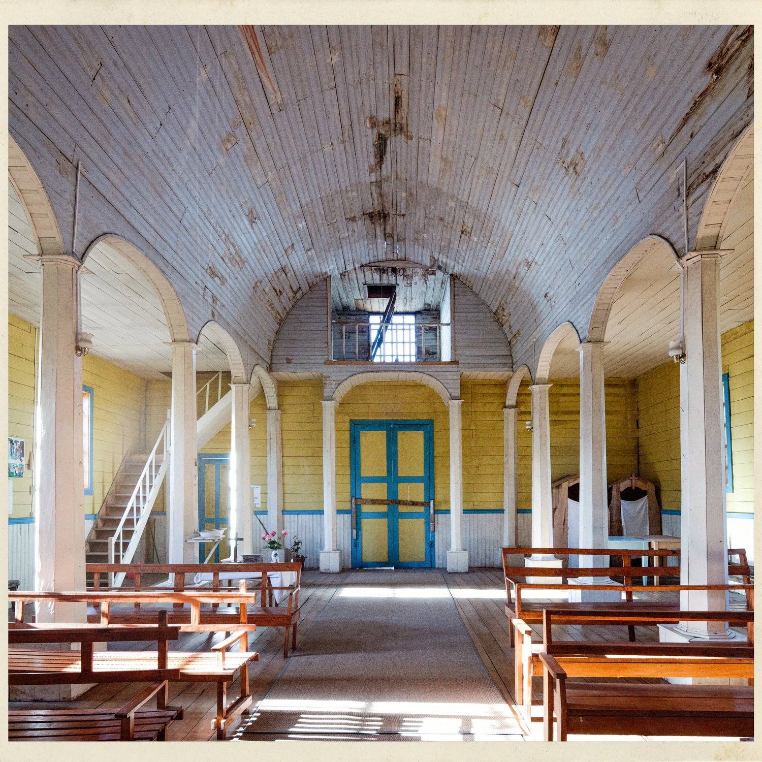 Interior de la iglesia de Lincay hacia la entrada, con el coro y la puerta azul
