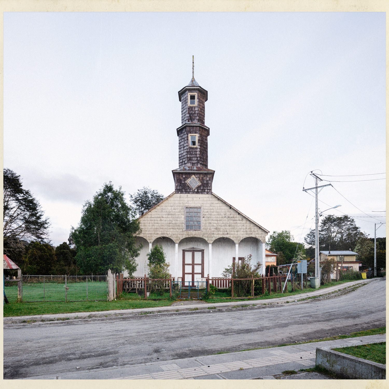 Fachada de la iglesia de Lincay con su torre alta, junto a la calle