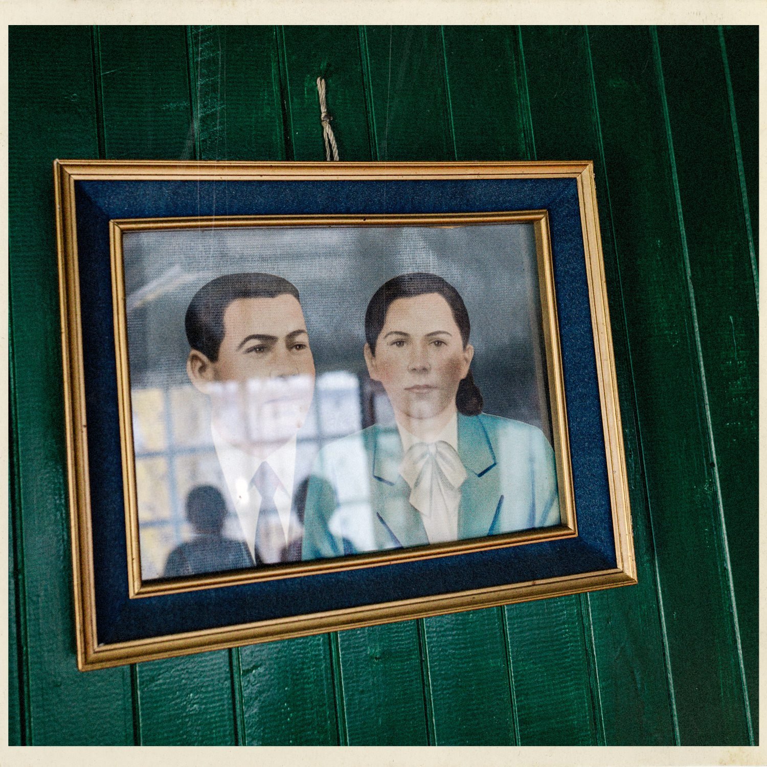 Retrato enmarcado de una pareja sobre una pared verde