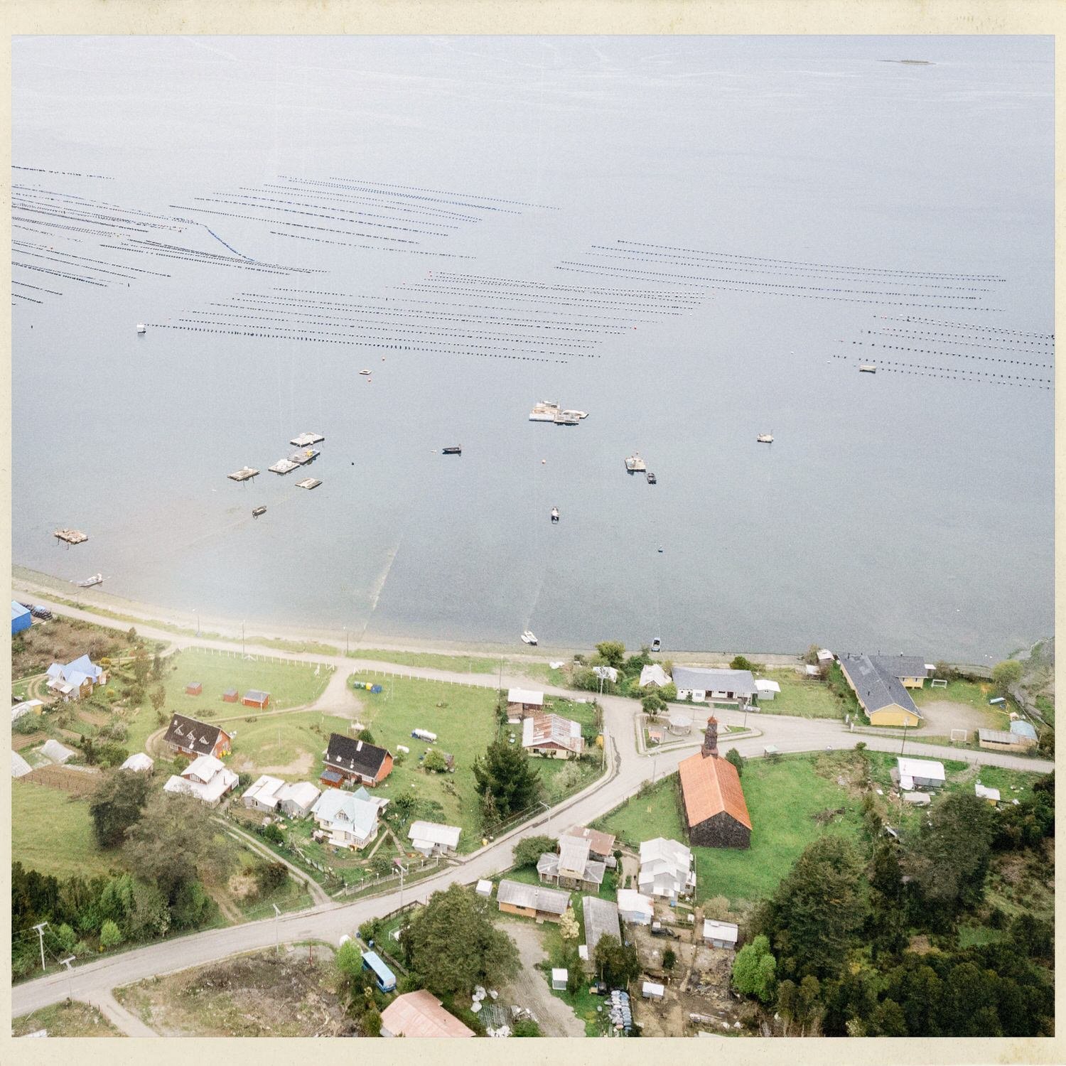 Vista aérea de la costa de Lincay con botes y líneas de cultivo en el mar