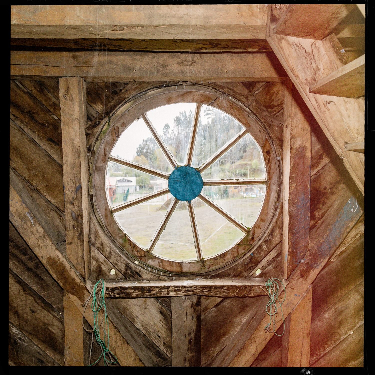 Ventana circular de madera vista desde el interior de la torre de la iglesia de Llingua