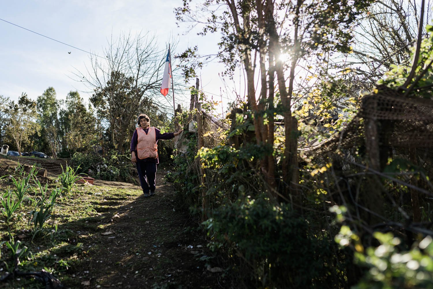 Una mujer camina por un sendero entre árboles, en la historia de doña Zaida y don Humberto, en Llingua