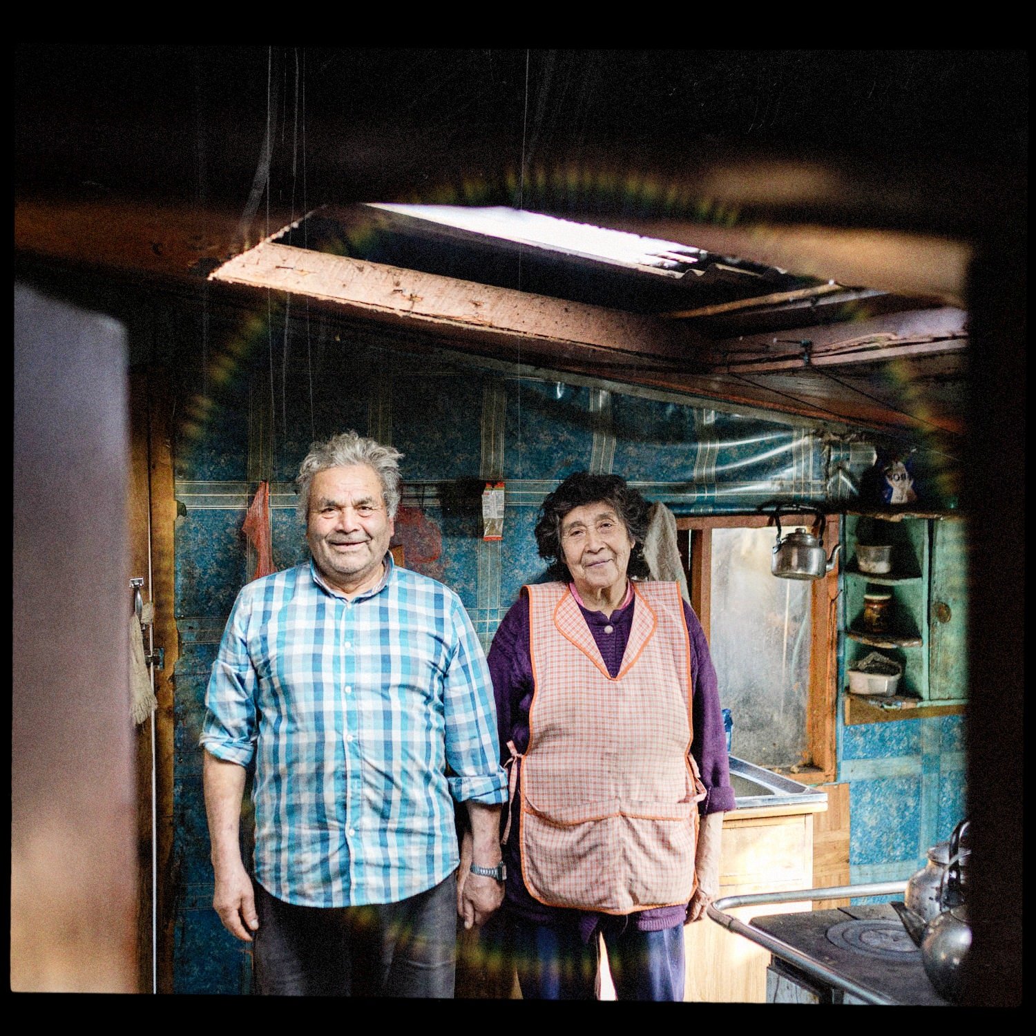 Doña Zaida y don Humberto de pie en la cocina de su casa, en Llingua