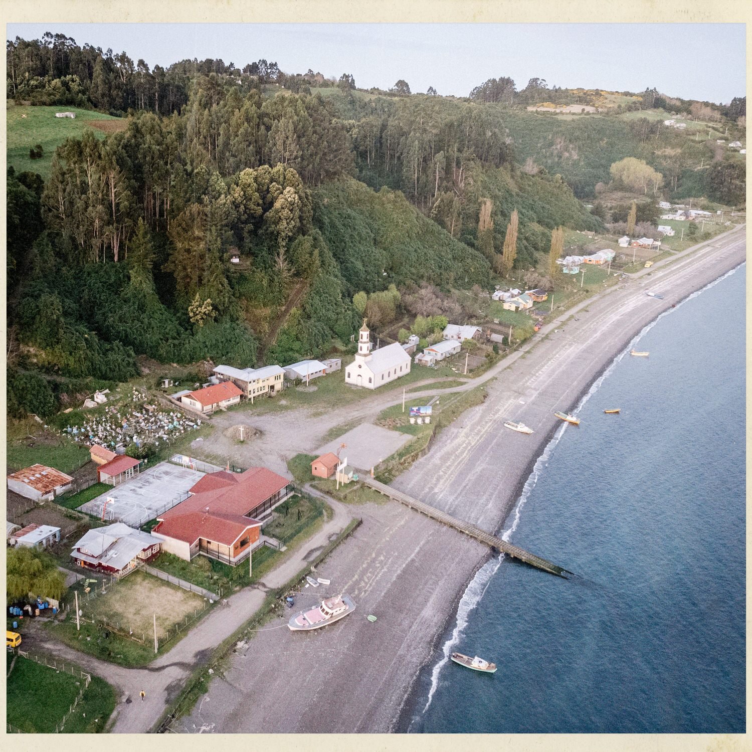 Vista aérea de la costa de Llingua con la iglesia, el cementerio y el muelle