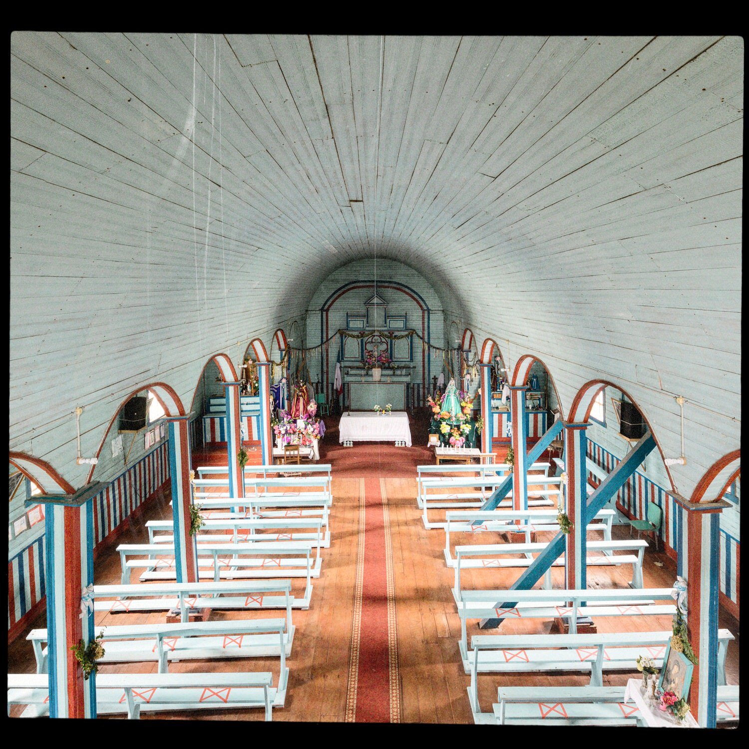Nave de la iglesia de Matao con bóveda celeste, columnas y bancas blancas
