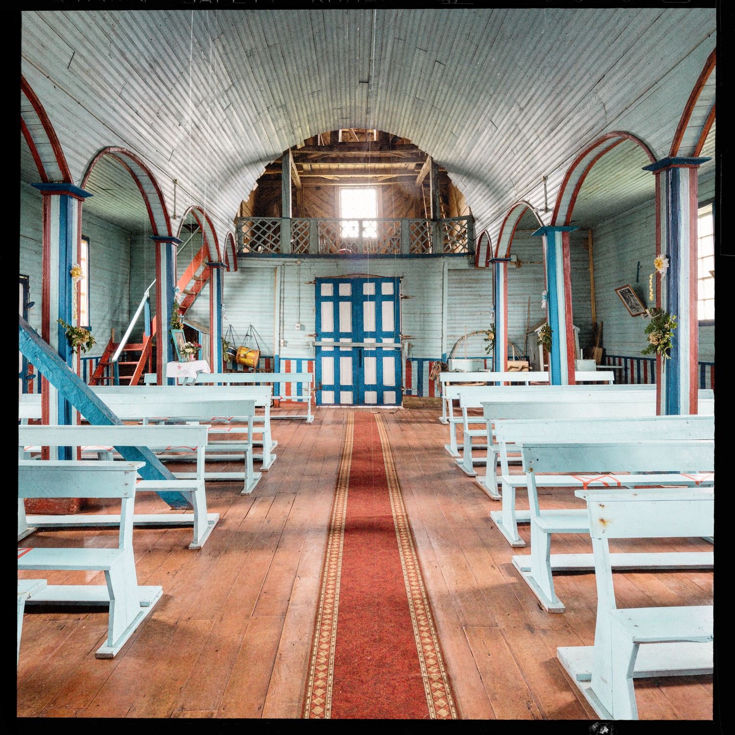 Interior de la iglesia de Matao hacia la entrada, con el coro y la puerta azul