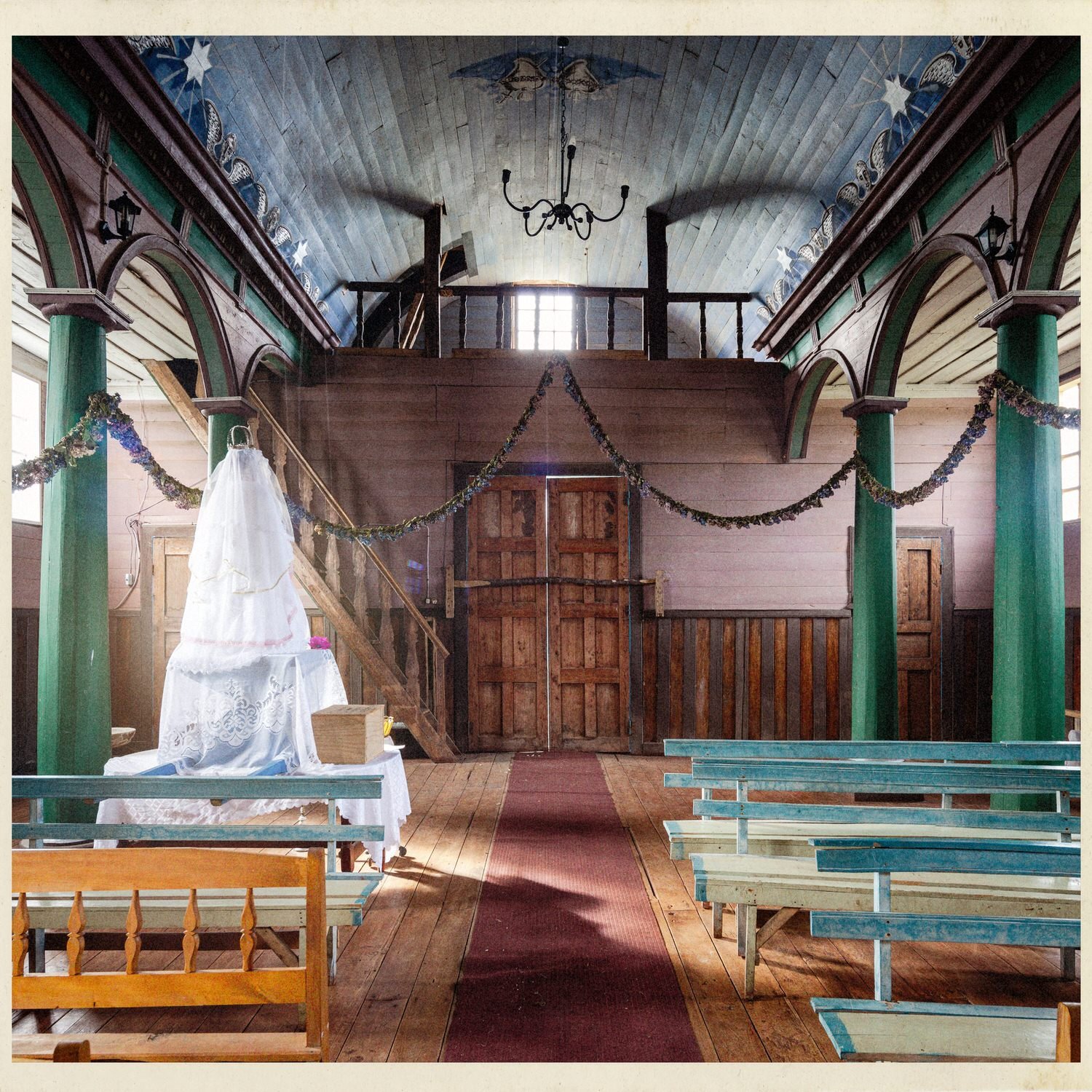 Interior de la iglesia de Puchilco hacia la entrada, con el coro y la puerta