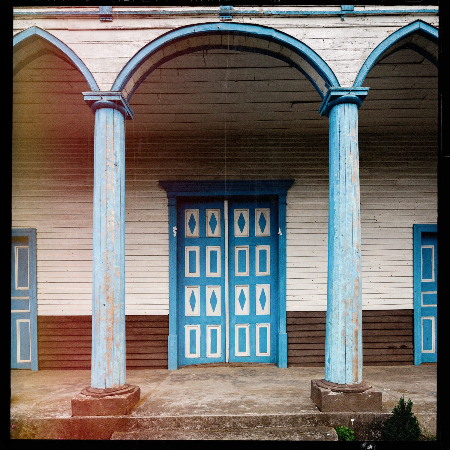 Puerta azul y columnas del pórtico de la iglesia de Puchilco