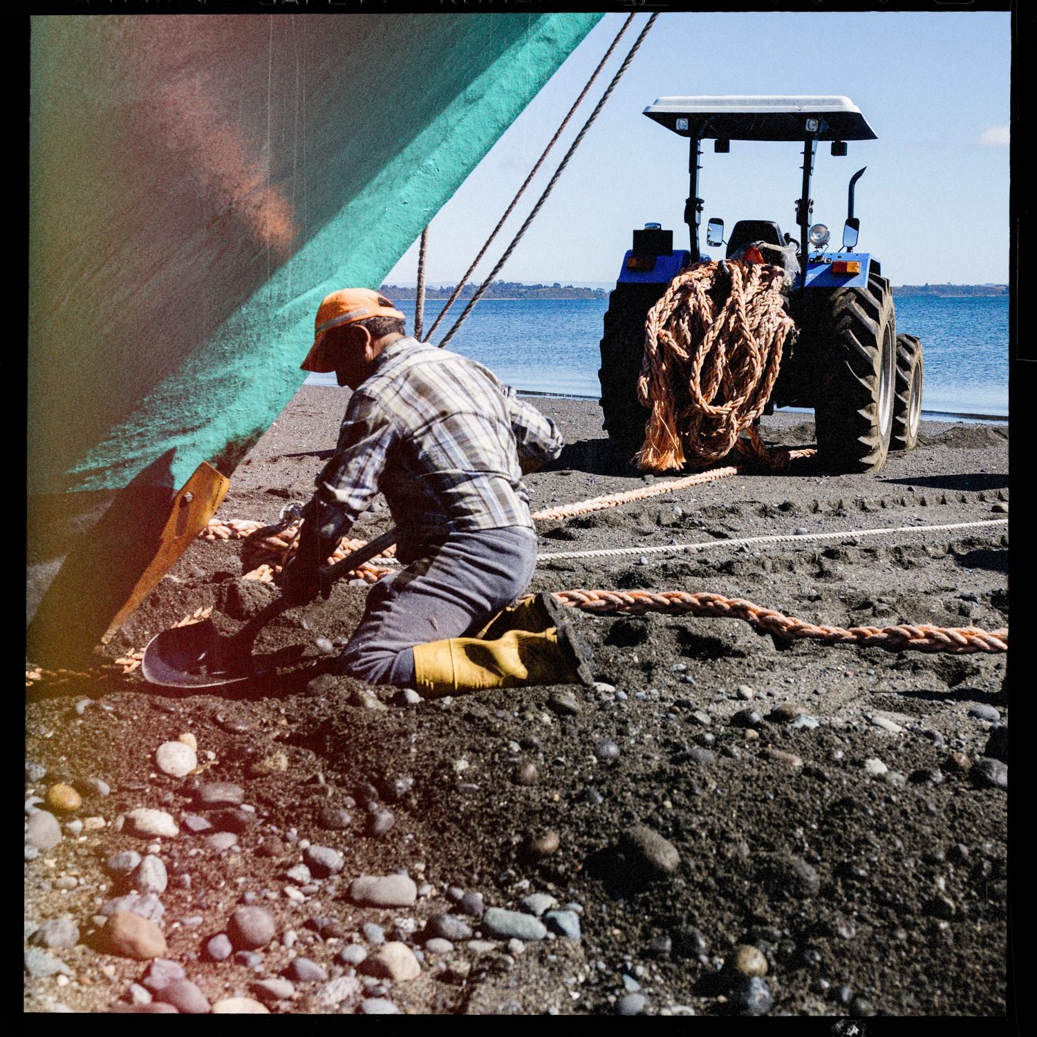 John Llanquin amarra cuerdas junto a un tractor en la playa