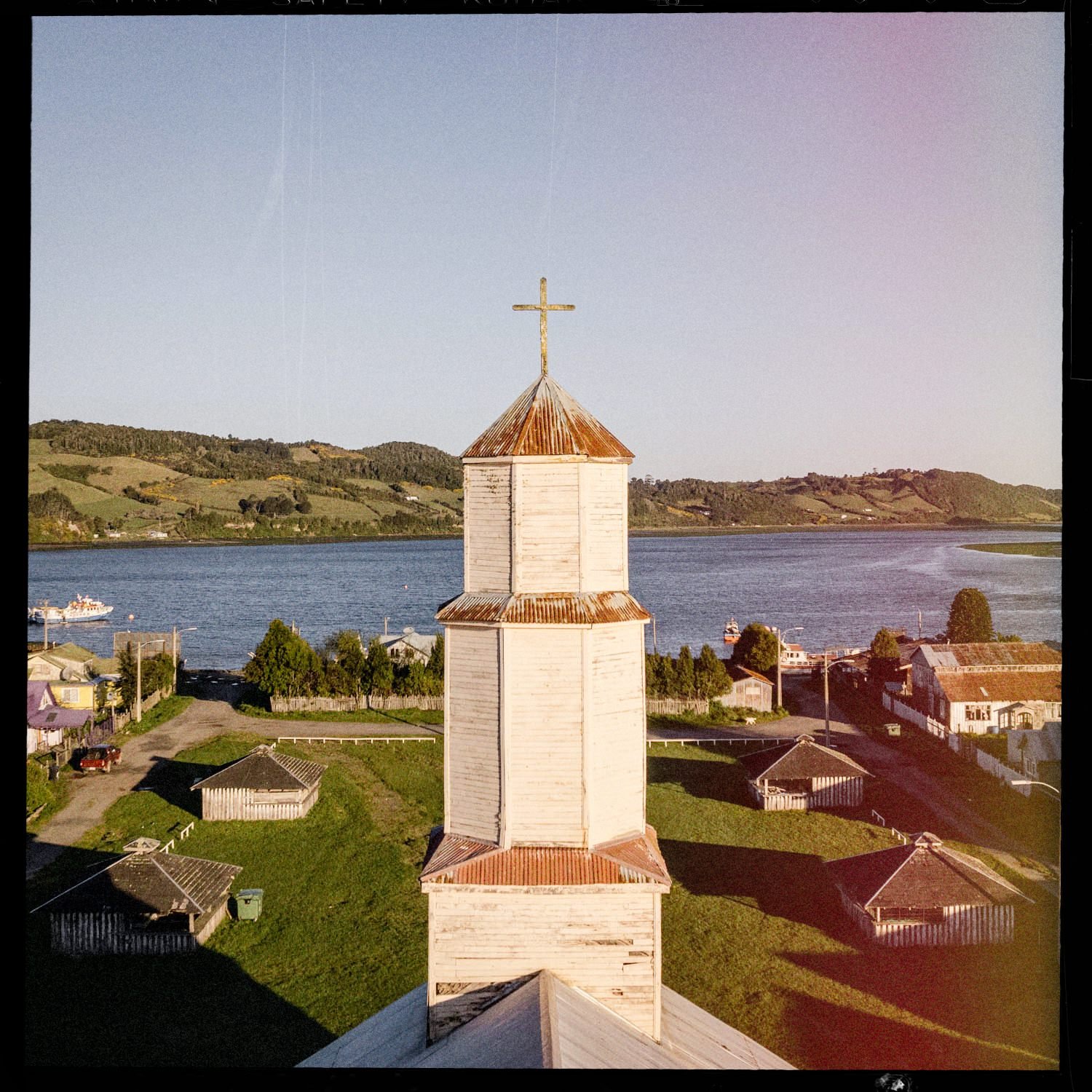 Torre de la iglesia de Quehui vista desde lo alto, con el estero y el caserío