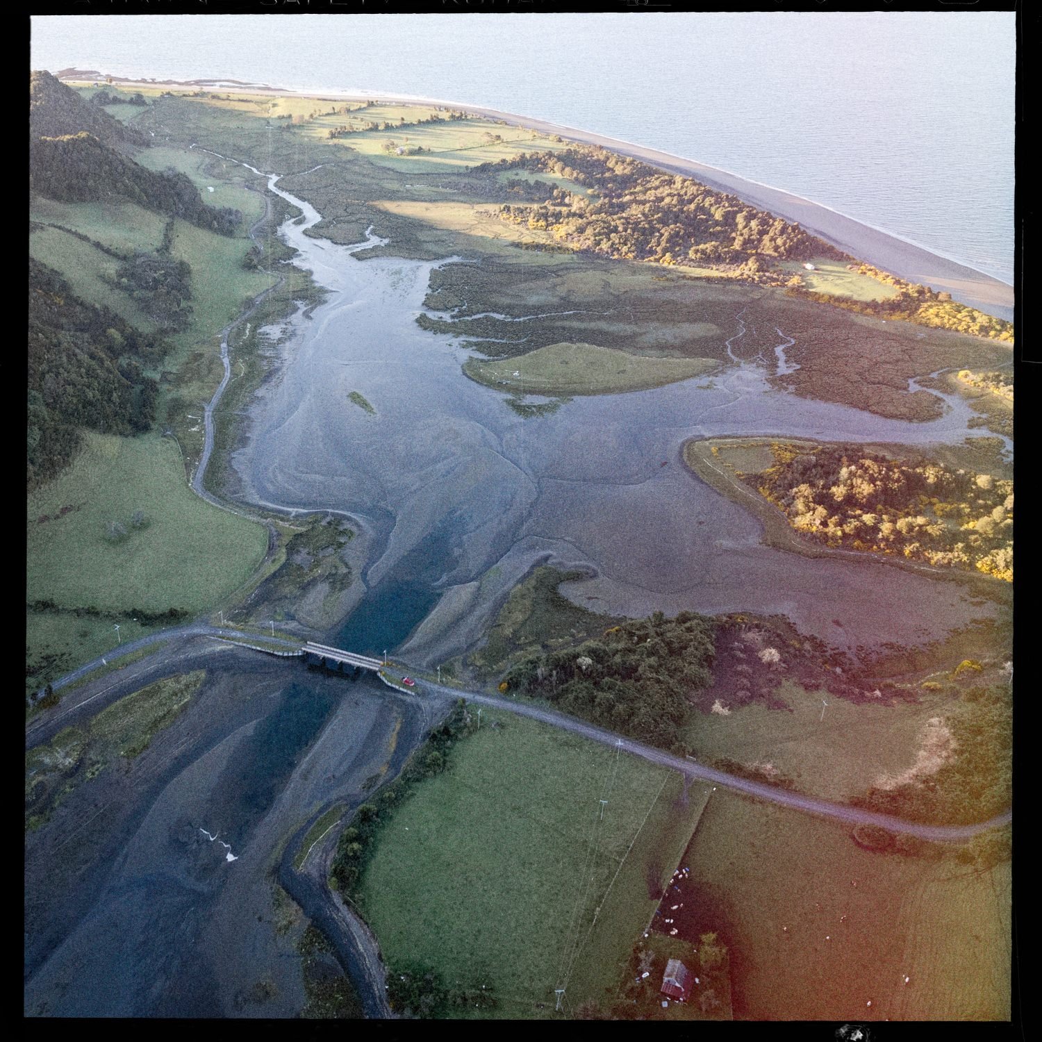Vista aérea del estero de Quehui con un puente y los campos