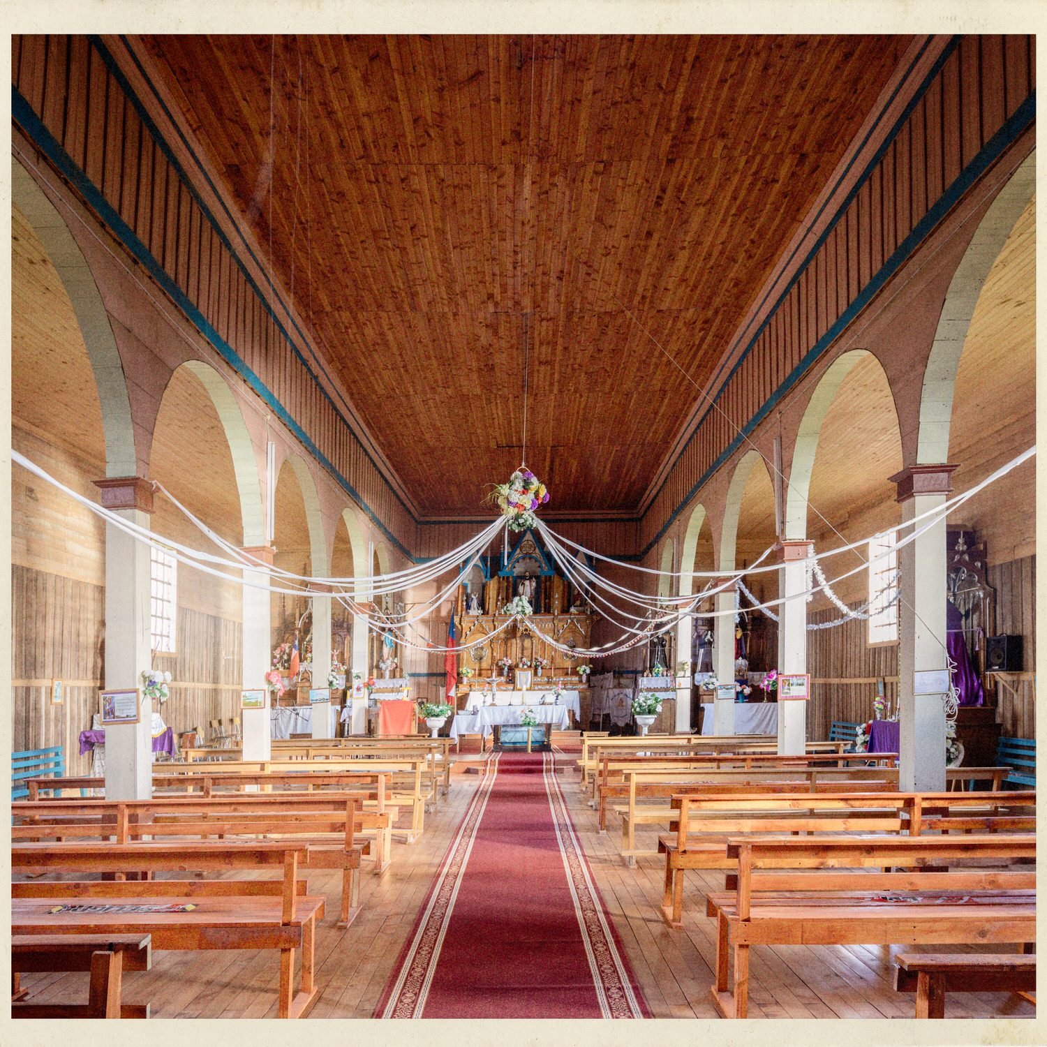 Nave de la iglesia de San Javier con cielo de madera, arcos y bancas
