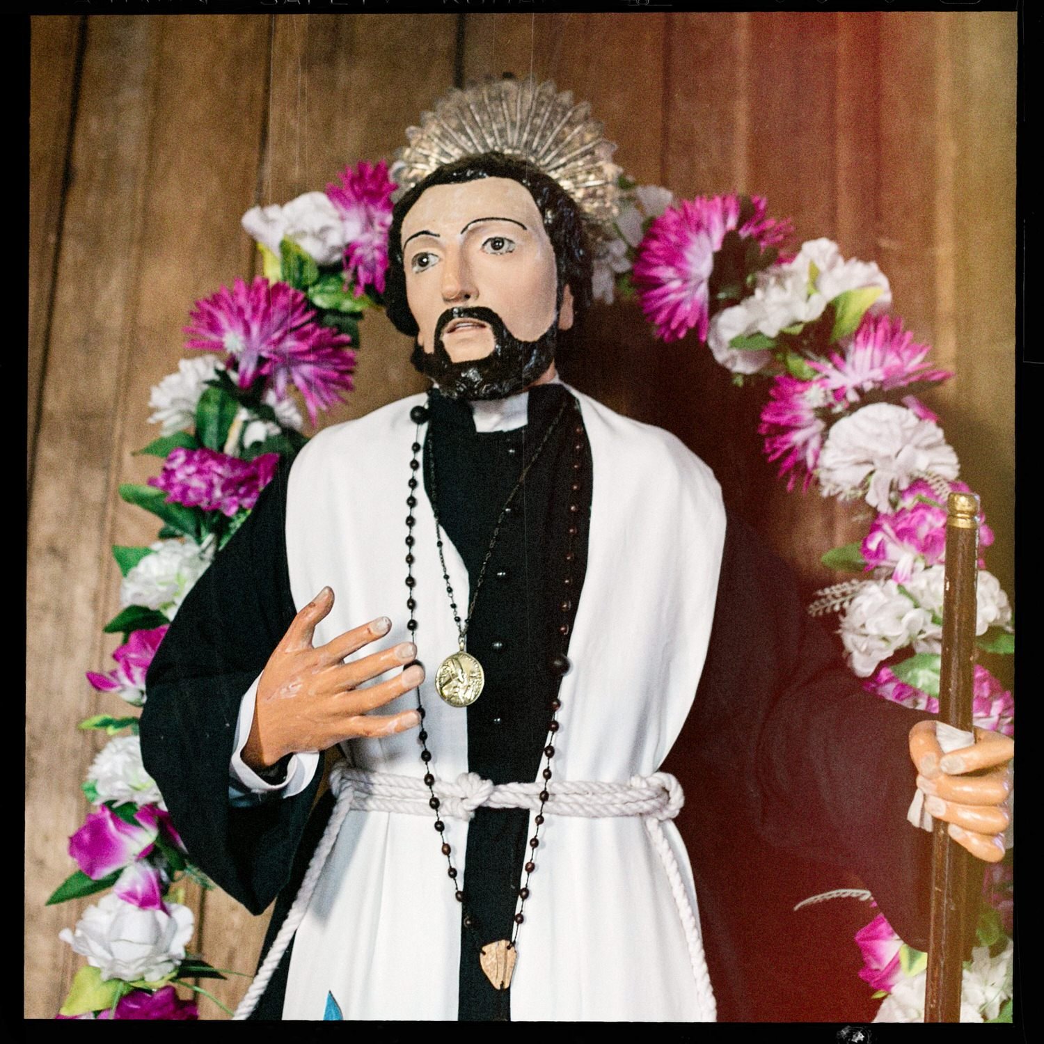 Imagen de un santo con sotana y roquete, rodeado de flores, en la iglesia de San Javier