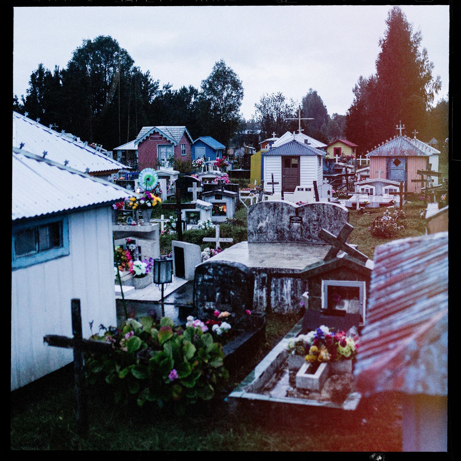 Casitas funerarias de colores en el cementerio de Teupa