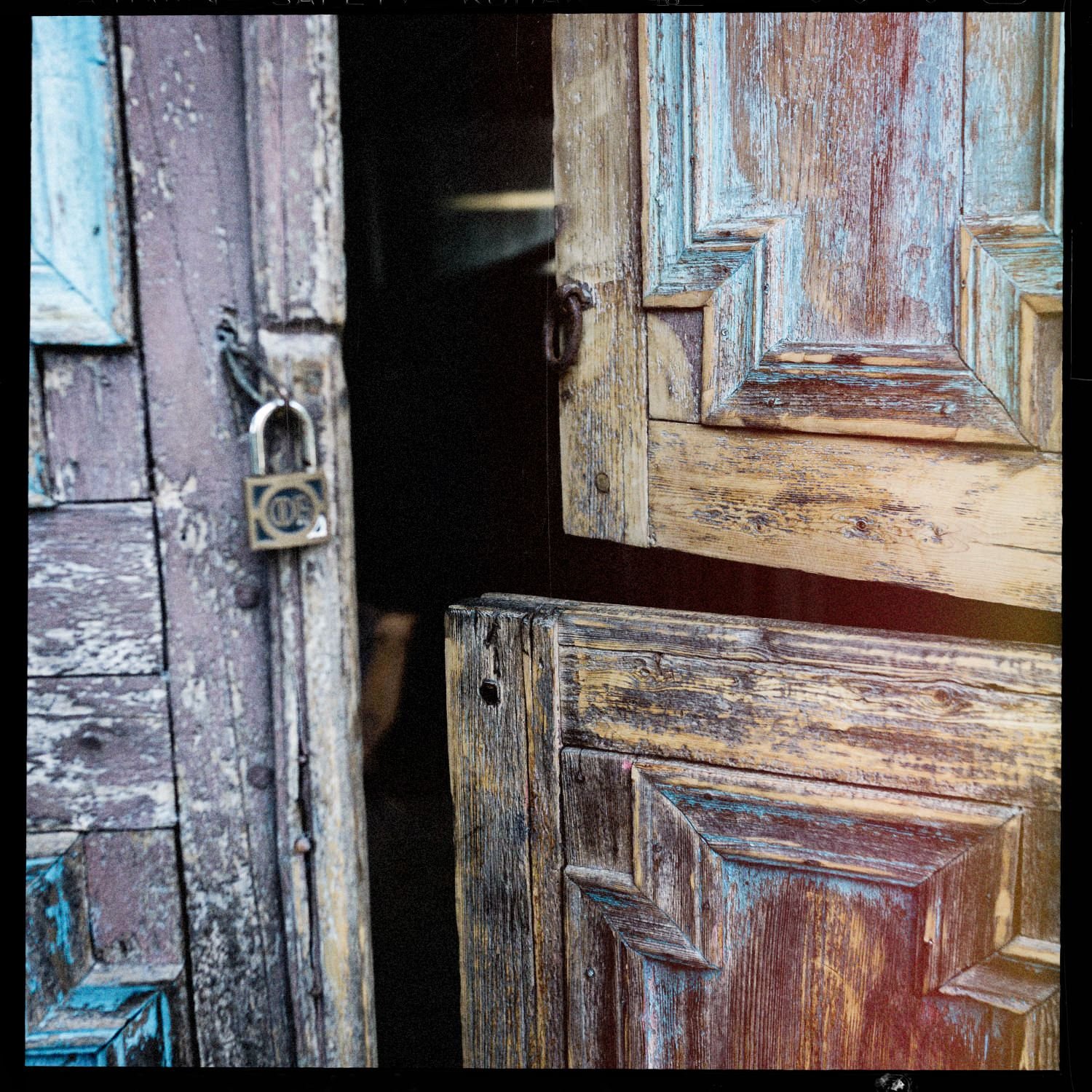 Puertas de madera antiguas con pintura descascarada y un candado