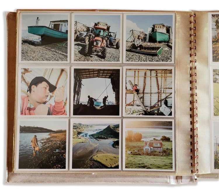 Álbum de fotos con escenas de actividades rurales y marítimas, como barcos en la playa, personas trabajando en construcciones, niños jugando, y pai…