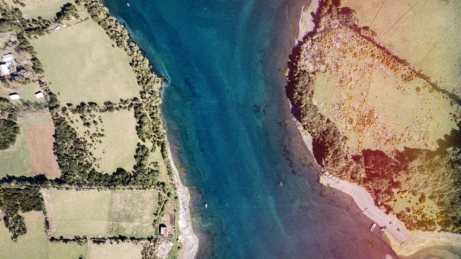 Vista aérea del borde costero de Apiao, con potreros y el mar