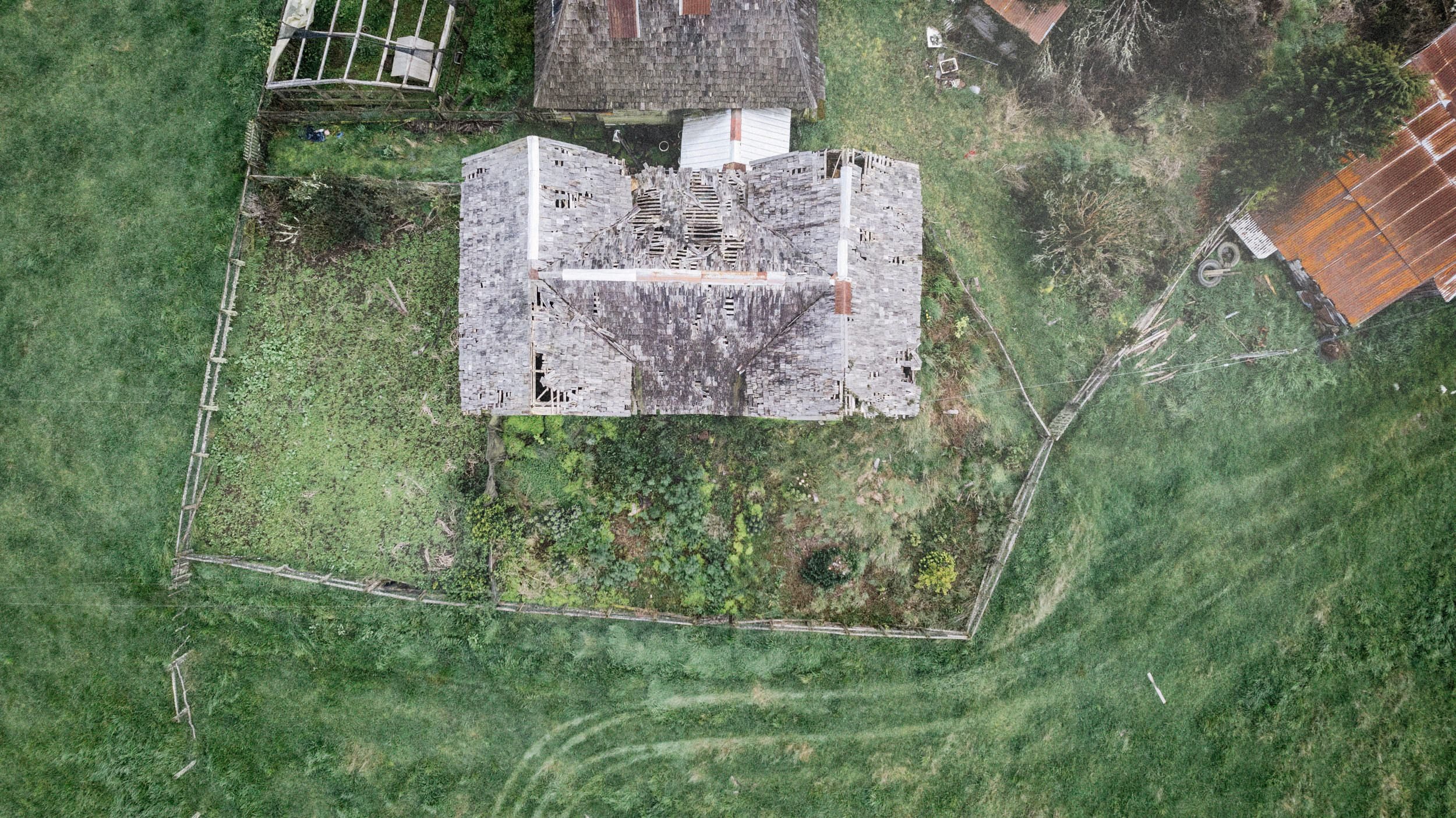 Vista cenital de una casa de tejuelas y su huerto, en Chullec