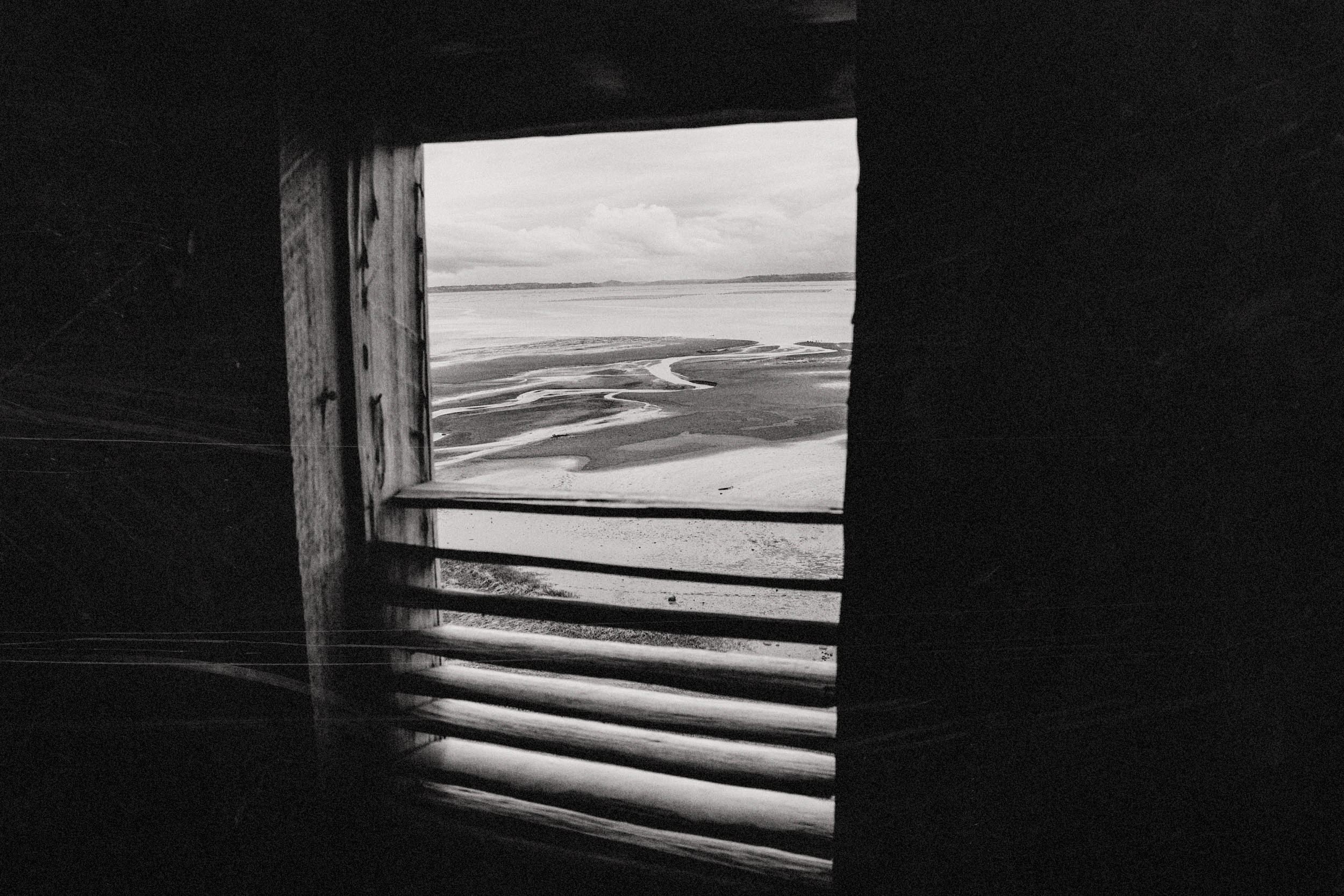 La marea baja de Chullec vista a través de una ventana, en blanco y negro
