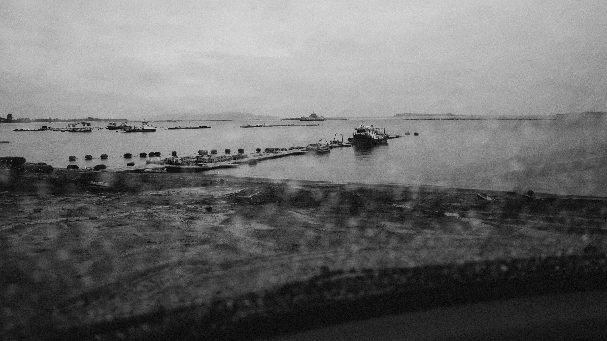 El mar y un muelle de Matao en un día gris, en blanco y negro