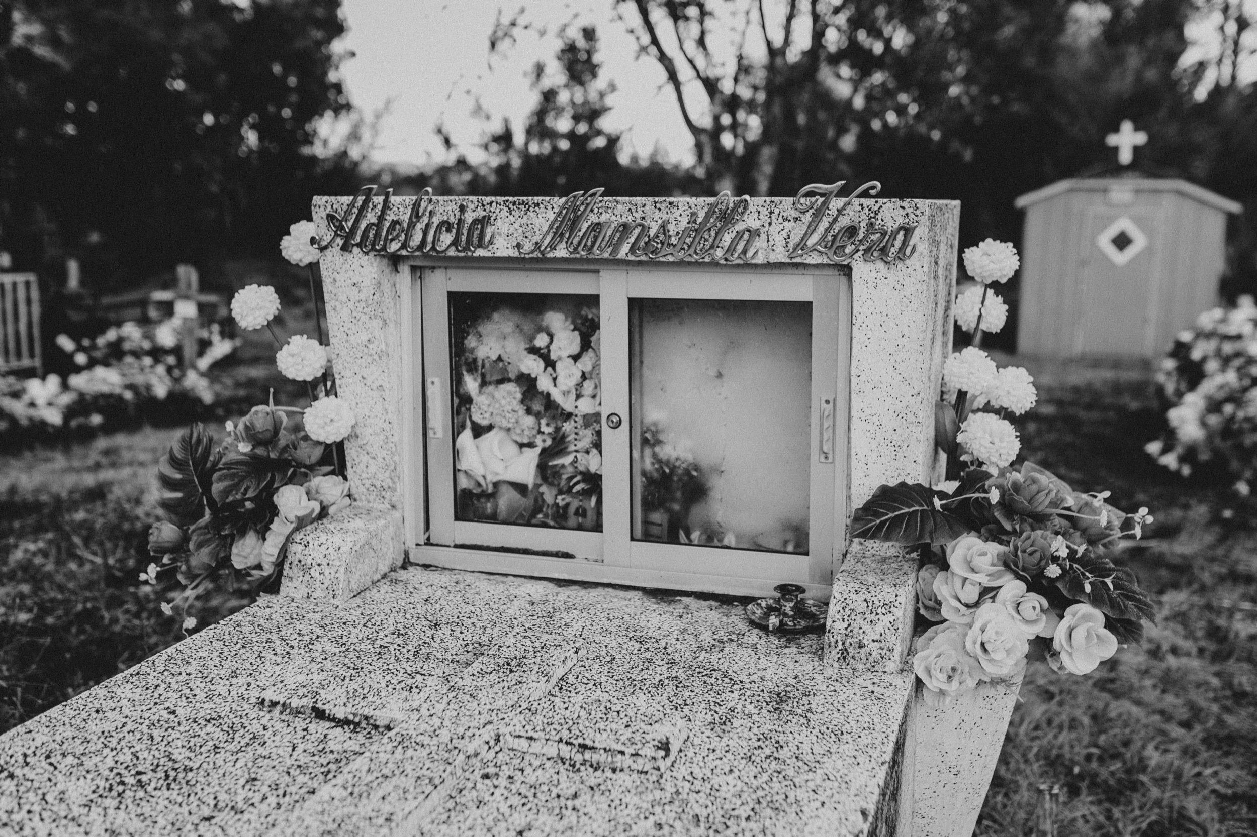 Una tumba con flores en el cementerio, en blanco y negro